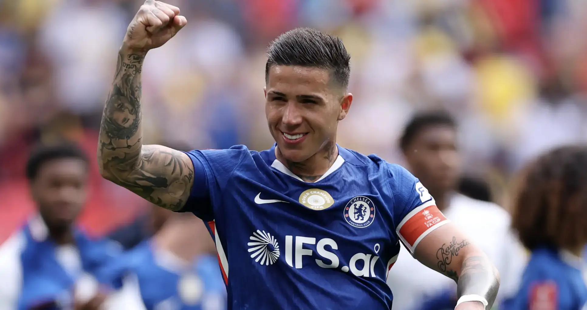 Chelsea FC footballer in blue kit raises a fist in celebration on the pitch