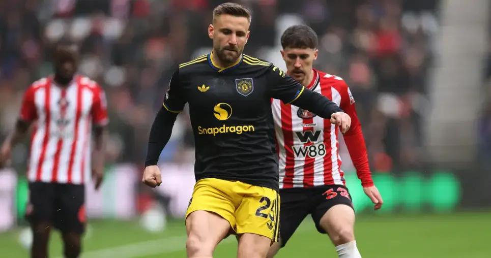 Wolves player in black and yellow shorts dribbles the ball while a red-and-white striped opponent challenges from behind on a green pitch.