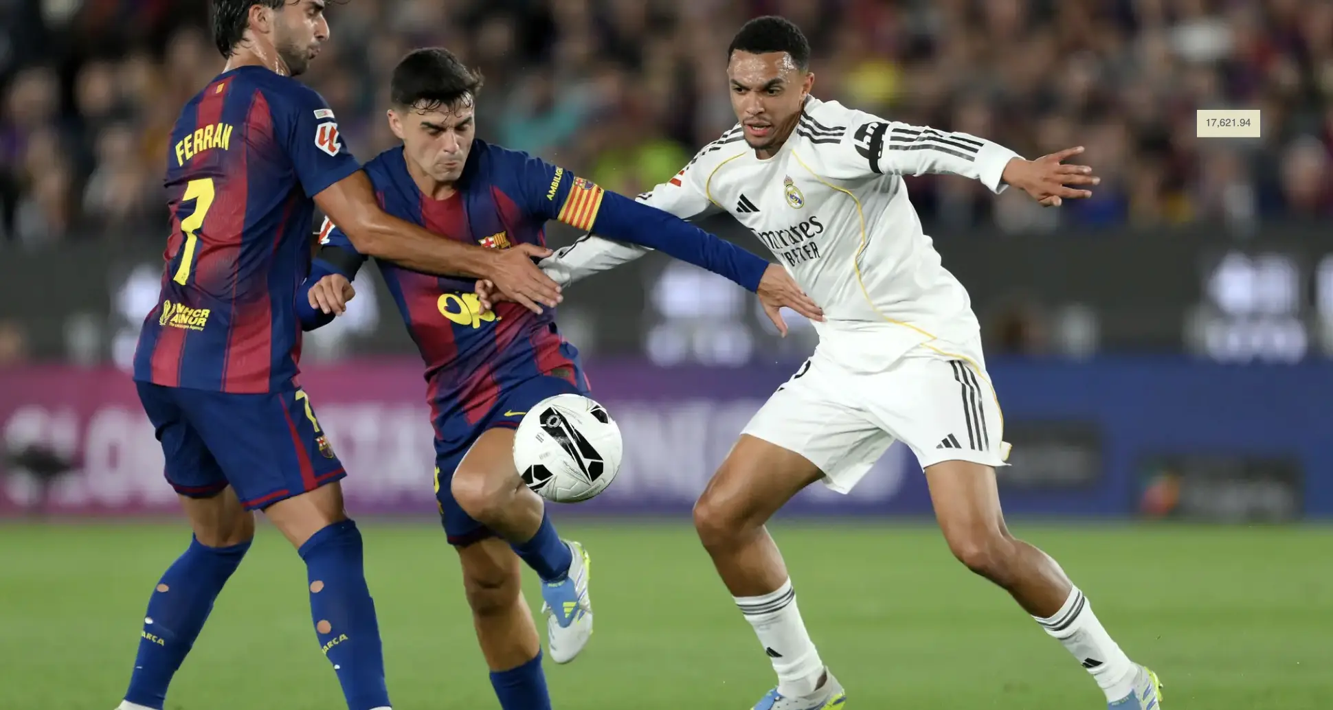 Two soccer players from Barcelona and Real Madrid contest the ball during a high‑tempo match, reaching in with arms and legs.