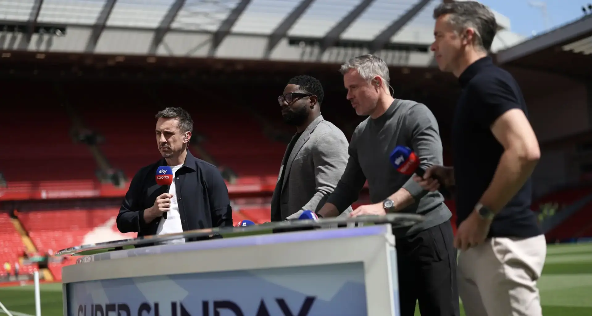 Sports reporters at a stadium press conference, standing behind a podium with microphones and Sky Sports logos.