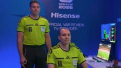 Two men in neon yellow uniforms pose at a Hisense booth with a computer monitor on a table against a blue backdrop.