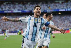 美斯梅開二度阿根廷30 - 實發體育 Argentine footballers celebrate a goal with arms outstretched on the pitch, stadium full of fans.