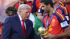 cover-8862-1784512853jpg - 實發體育 Former President Donald Trump congratulates a soccer player in a red jersey holding a gold trophy during a presentation ceremony.