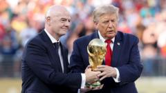 Two men in suits on a stadium field presenting a gold trophy together (award moment).