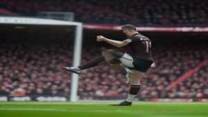 Soccer player in a maroon jersey kicking the ball during a match on a packed stadium field