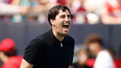cover-9109-1785722424jpg - 實發體育 Man in a black shirt shouting passionately on a sports sideline, with spectators blurred in the background.