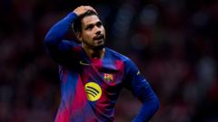 Footballer in Barcelona jersey with Spotify logo, hand on head, on a blurred stadium background.
