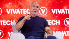 Speaker on stage at a tech conference, gesturing while seated in front of a red VivaTech backdrop with logos.