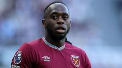 Male footballer wearing a claret West Ham United jersey, looking ahead on the pitch.