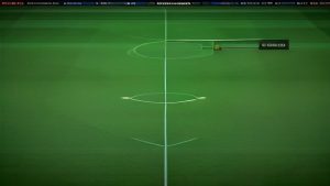 cover-9321-1787443249jpg - 實發體育 Aerial view of a soccer field showing the center line and center circle with a camera setup along the sideline nearby for broadcasting.