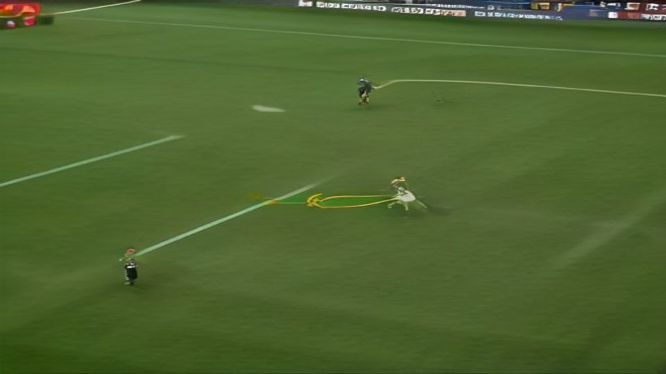 Soccer match: a white-jersey player advances with the ball on a green field, a yellow curved trail marks the ball's path.
