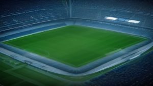 A soccer stadium with a lush green pitch and empty stands surrounding it.