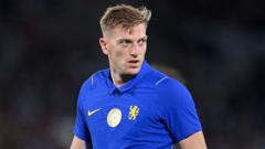 Soccer player wearing a blue jersey with a yellow crest, looking off to the side on the field.