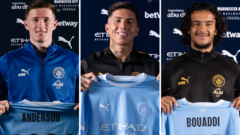 cover-9418-1788400824jpg - 實發體育 Three football players stand side by side, each holding a club jersey; the left jersey reads 'ANDERSON' and the right reads 'BOUADDI'